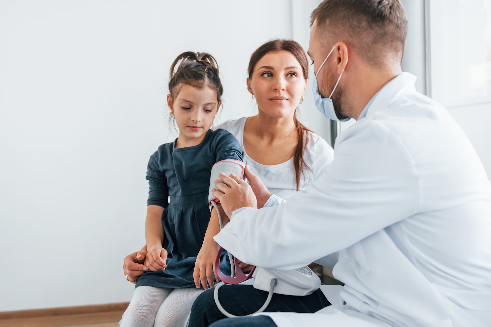 Helping kid. Two doctors in white coats is in the clinic working together